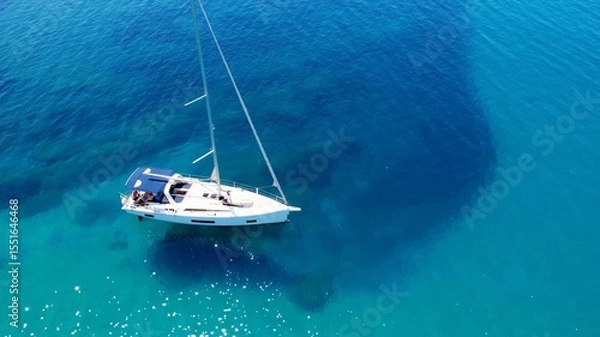 Fototapeta Sailboat Gliding on Crystal Clear Waters Near Vibrant Coral Reef in Sunny Coastal Location