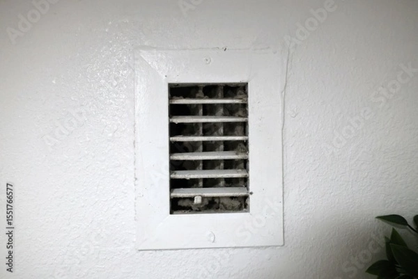 Fototapeta dust and dirt buildup visible on the wall-mounted air conditioner's exhaust vent showing lack of maintenance and poor air quality in close up view