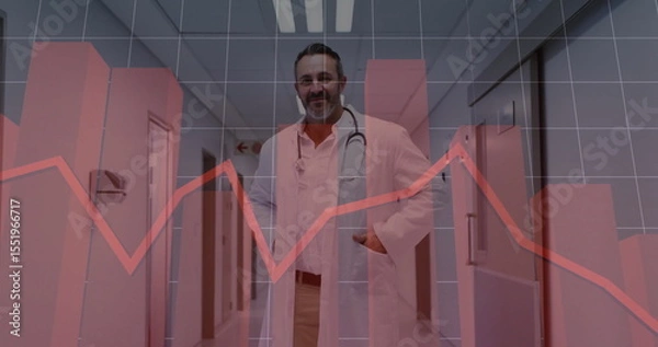 Obraz Standing doctor wearing coat, scrubs, stethoscope in hospital corridor, with red line graph overlay