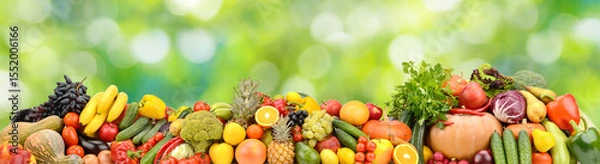 Fototapeta Photo of bright healthy fruits, vegetables and berries on a green natural background.