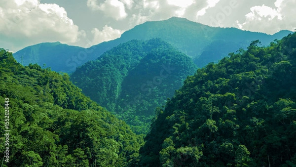 Fototapeta Towering green mountain reaching the clouds in the rainforest of Tingo María, Peru.