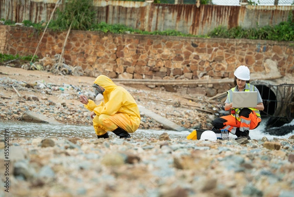 Fototapeta Environment scientist with team analysing waste water test results and collecting sample for research or inspection of the ecosystem and study of nature from an industrial factory into the sea