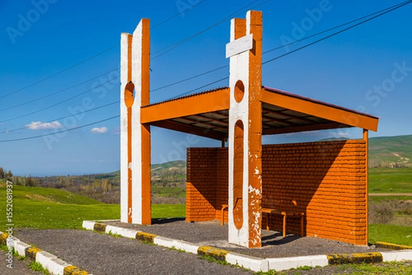 Obraz Serene bus shelter on grassy hillside in rural daytime Kyrgyzstan setting