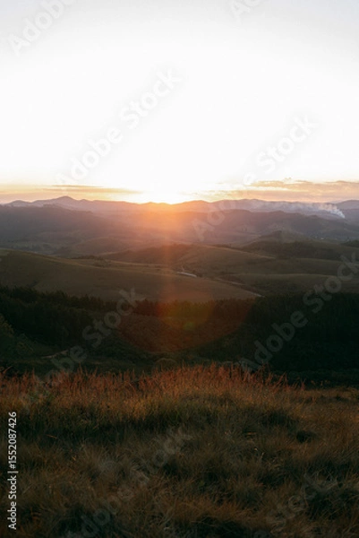 Obraz Reddish, golden and orange sunset between mountains
