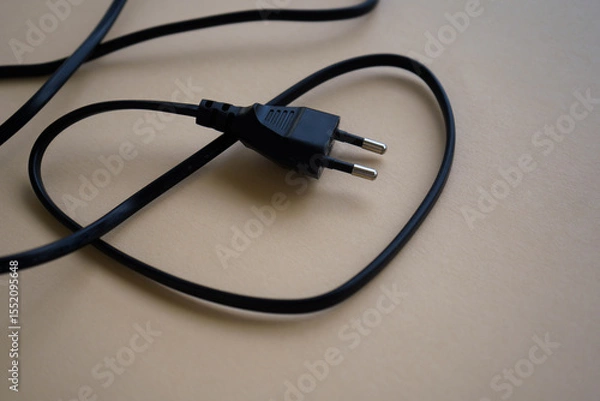 Obraz Electric European plug isolated on beige background. Black power cable with plug. Power cord close-up