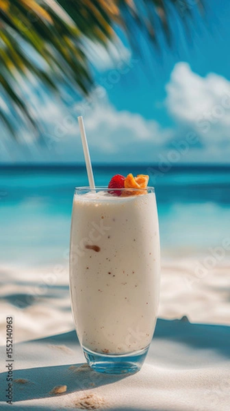Obraz A beautiful glass of fruit creamy milkshake cocktail with a straw, wooden table overlooking a serene beach, offering a perfect blend of refreshment scenic ocean view.copy space.verical