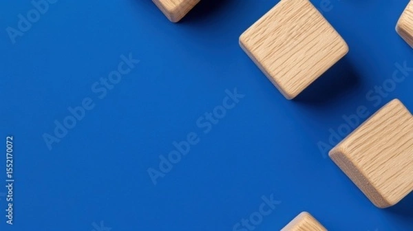 Fototapeta Abstract wooden blocks on vibrant blue background, symbolizing creativity and minimalism.