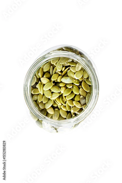 Obraz Top view of a glass jar full of shelled pumpkin seeds.