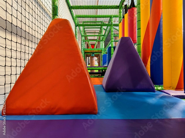 Fototapeta Colorful Multicoloured Vibrant Indoor Soft Obstacle Jungle Gym Course At A Kids Playground Without Logos Or Trademarks.
