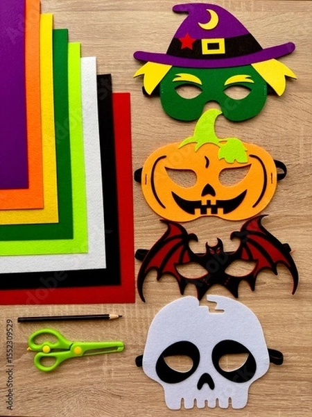 Fototapeta Halloween. DIY Felt Halloween Masks. Felt masks and felt sheets are lying on the table. Set of Various Masks, monsters, Pumpkin, Devil, Witch, Skeleton, Bat, DIY Toys, Dress Up Mask, Game Accessories.