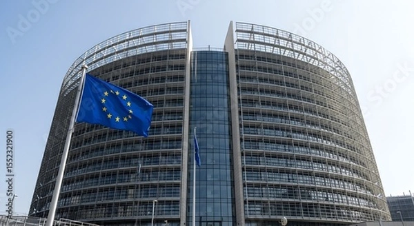 Fototapeta Modern glass building with EU flag waving in front. Headquarters of European Commission symbolizing governance, unity, and politics in the European Union.