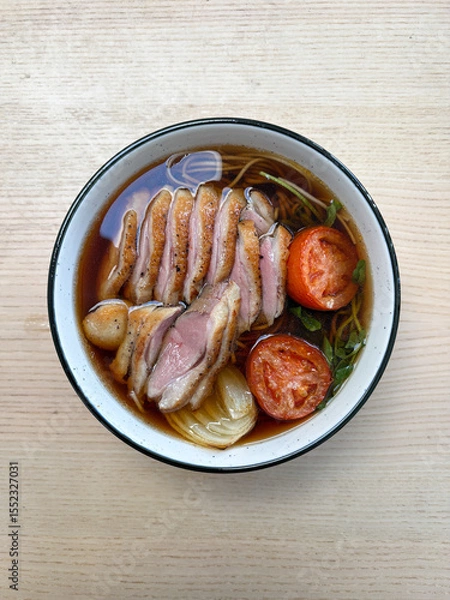Fototapeta A bowl of noodle soup with duck breast.