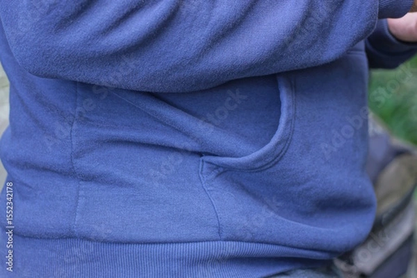 Fototapeta part of a blue autumn jacket on a man from an open pocket on a city street