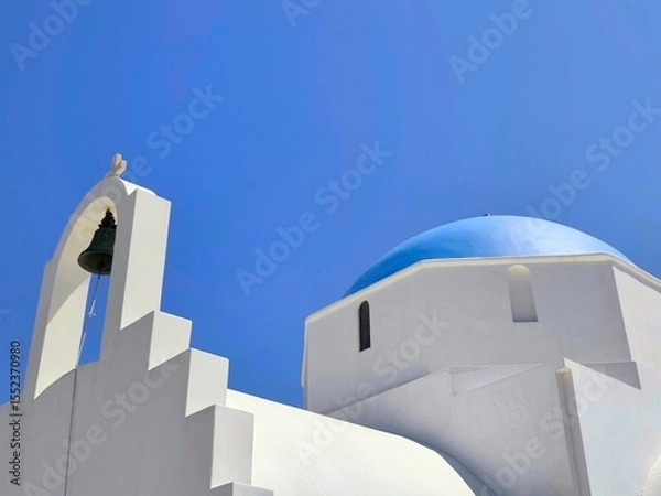 Fototapeta Closeup view of the Holy Chapel of Agia Marina in Antiparos, Greece – A beautiful whitewashed Orthodox church with a classic Cycladic blue dome, welcoming visitors at the island’s picturesque port.