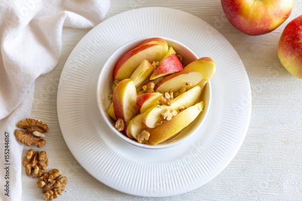 Fototapeta Healthy vegetarian Salad with apples, walnuts and honey in bowl. Top view