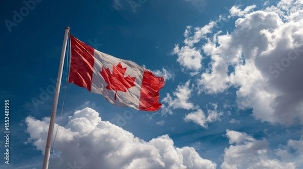 Fototapeta Canadian Flag flailing in the wind. Blue sky with clouds in background