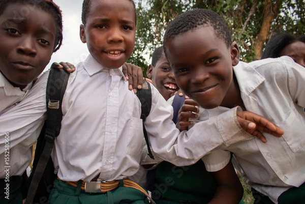 Fototapeta Premium close-up of happy African schoolchildren in uniforms, laughing together outdoors. A powerful and uplifting image capturing real joy, childhood, and cultural connection.