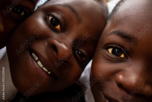 Fototapeta Premium close-up of happy African schoolchildren in uniforms, laughing together outdoors. A powerful and uplifting image capturing real joy, childhood, and cultural connection.