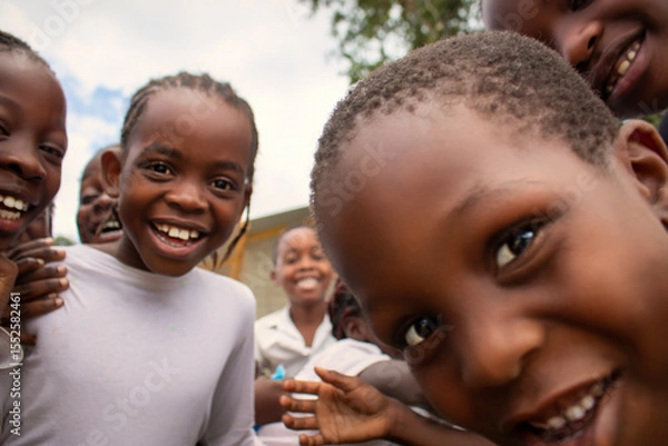 Fototapeta Premium close-up of happy African schoolchildren in uniforms, laughing together outdoors. A powerful and uplifting image capturing real joy, childhood, and cultural connection.