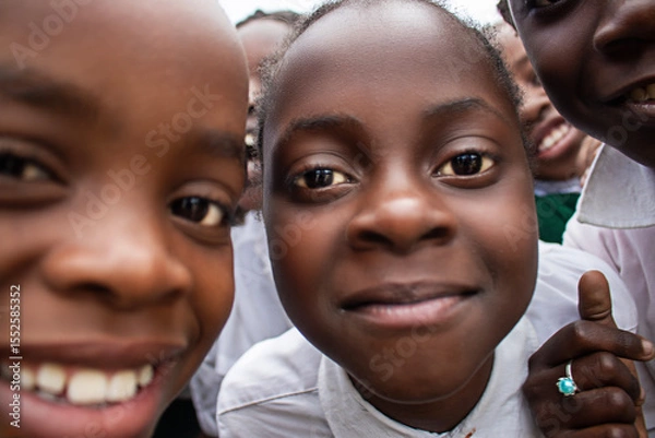 Fototapeta Premium close-up of happy African schoolchildren in uniforms, laughing together outdoors. A powerful and uplifting image capturing real joy, childhood, and cultural connection.