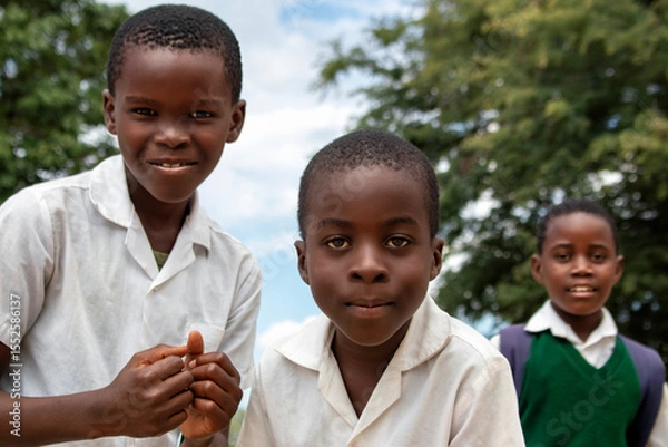 Fototapeta Premium close-up of happy African schoolchildren in uniforms, laughing together outdoors. A powerful and uplifting image capturing real joy, childhood, and cultural connection.