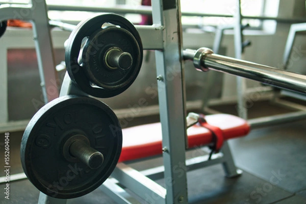 Fototapeta Close-up view of dumbbells, black circular weights, in a gym. 10-kilogram weight. View of weights in a gym.