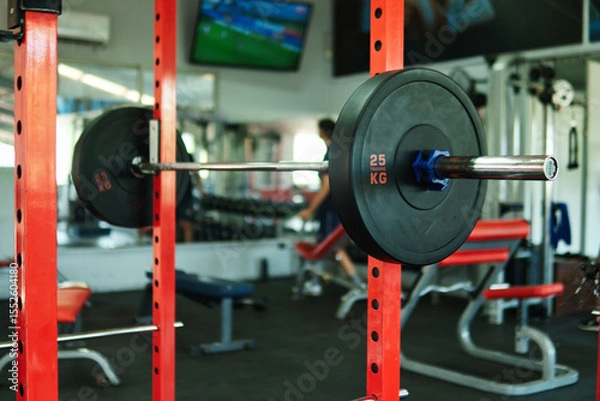 Fototapeta Close-up view of dumbbells, black circular weights, in a gym. 10-kilogram weight. View of weights in a gym.