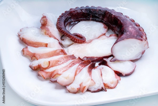 Obraz Raw Tentacles of octopus on white plate on white background, kraken tentacles sashimi isolate on white background.