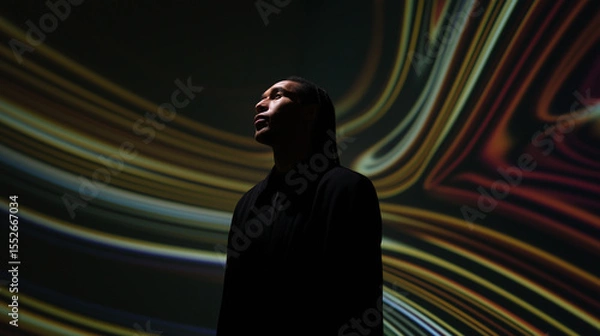Obraz A silhouetted figure stands within a vibrant tunnel of glowing purple and blue abstract light, representing technology, future, and digital experiences.
