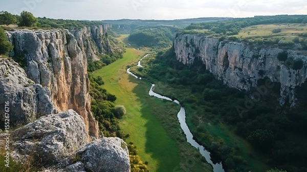 Obraz Green valley with a narrow river snaking between towering cliffs