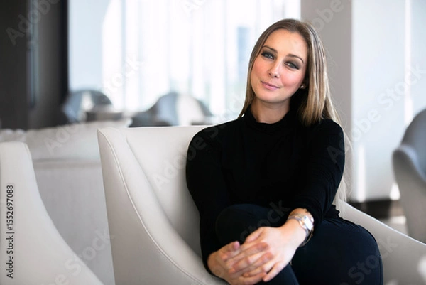 Obraz Confident Woman Relaxing in a Modern Lounge Space During Daylight With Stylish Interior Design Elements