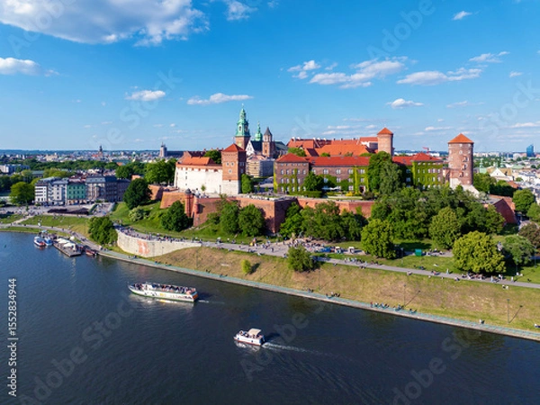 Fototapeta Poland, Krakow. Wawel Cathedral and Polish state owned Royal Wawel castle. Vistula river with tourist ships and boats, small harbor, boulevards, parks, walking and biking people. Copy space