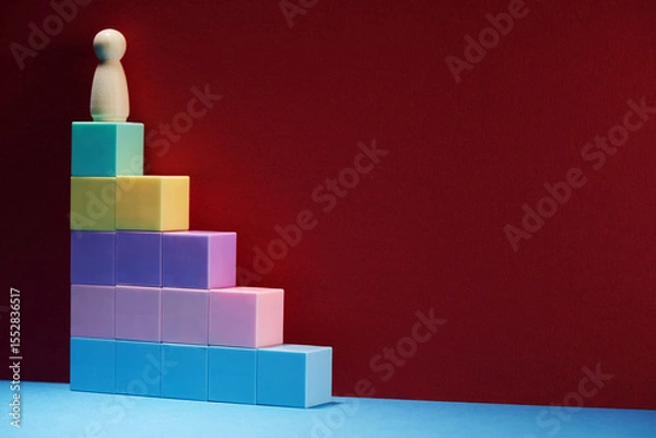 Obraz wood figurine  on top of colorful toy blocks
