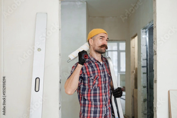 Fototapeta construction worker guy with a drill on a white wall background.master for an hour.