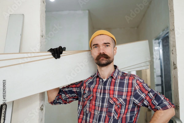 Fototapeta construction worker guy with a drill on a white wall background.master for an hour. construction worker guy with a drill on a white wall background.master for an hour. laying laminate flooring in an a