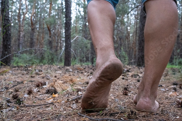 Obraz Hiking in the woods. Barefoot man walking in the forest.