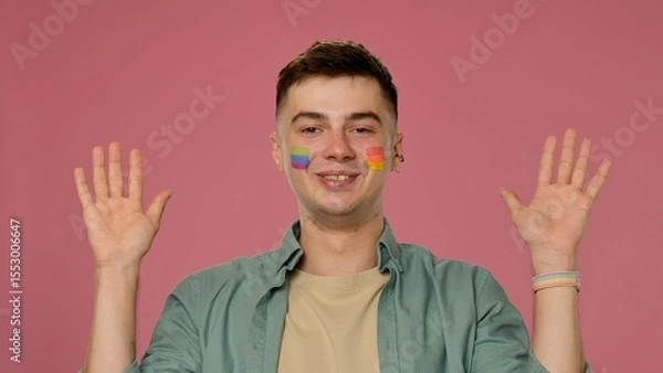 Fototapeta Smiling Individual with Colorful Face Paint and Raised Hands
