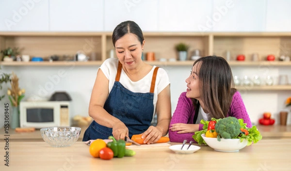 Obraz Cooking Skills and Connection. Women enjoying vibrant vegetables in a bright kitchen.