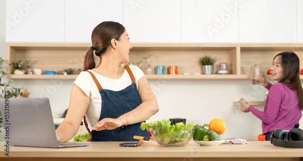 Obraz Healthy Cooking and Connection. Women enjoying healthy food preparation in a bright kitchen.