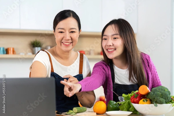 Obraz Healthy Cooking Together. Two women enjoying a cooking session with fresh vegetables.