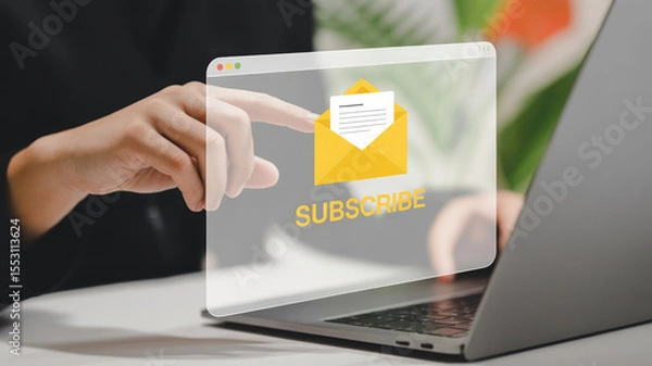 Fototapeta A laptop screen with a yellow envelope and a hand pointing to the word "subscribe" on the screen