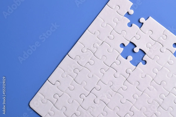 Obraz White puzzle pieces on blue background. White square puzzle pieces grid. Business background. Copy space for text, top view.