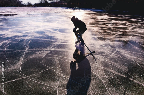 Fototapeta A person is skating on a frozen lake