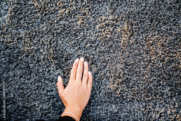 Obraz a woman's hand touching the grey Interior pile carpet
