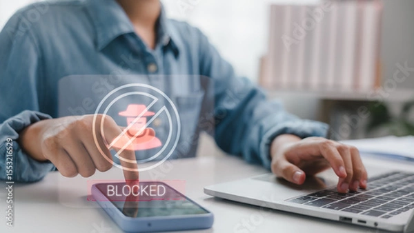 Obraz User blocking scam caller on smartphone with hacker icon and blocked symbol. Concept of mobile security, cyber fraud prevention, and protecting personal data from suspicious activities.