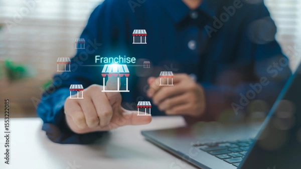 Obraz Businessman touching virtual franchise icon with shop symbols, concept of franchise model, business growth strategy, investment opportunity and retail expansion network.