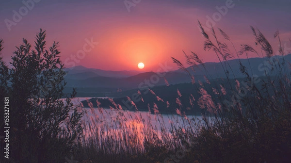Fototapeta Stunning sunset paints the sky with vivid hues over a tranquil lake and mountains.