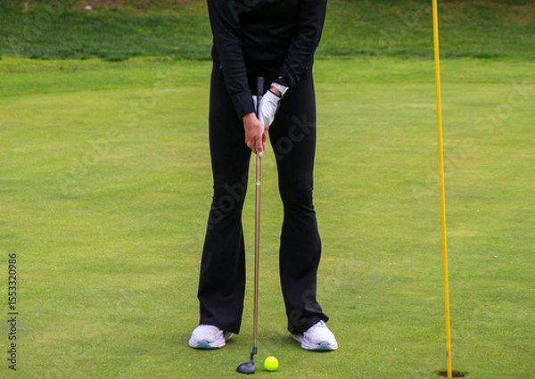 Obraz Golfer Prepares to Putt on a Lush Green Golf Course