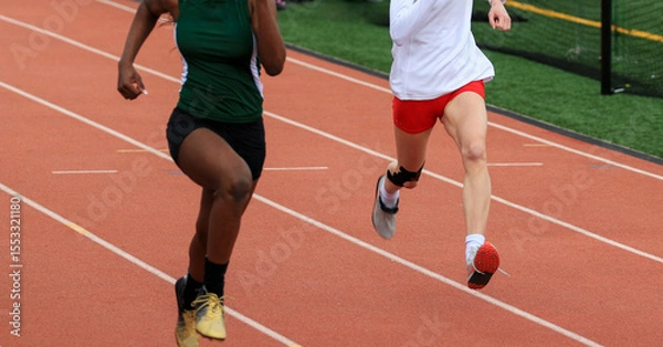 Obraz Runners Competing on a Track During a School Athletics Event