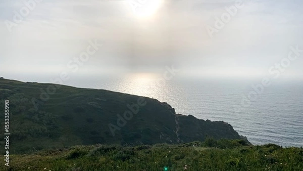 Fototapeta Sunlit whispers kiss misty coastal cliffs, invoking tranquil Celtic mythos and Lughnasadh Festival, where nature's serenity reigns